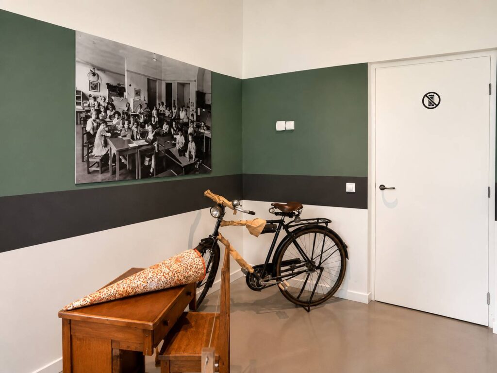 Museumruimte in het Anne Frank Huis met historische foto, fiets en tentoonstelling
