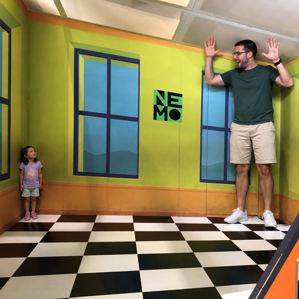 Optische illusie kamer in NEMO Science Museum waar bezoekers door perspectief groter en kleiner lijken