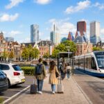 P+R parkeerplaats met tram, trein en Nederlandse stad op de achtergrond